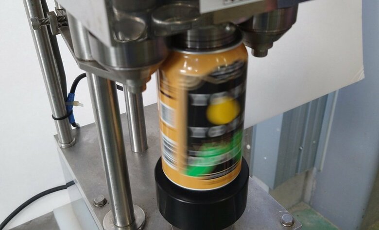 「巻き締め機」で缶のフタをしめる