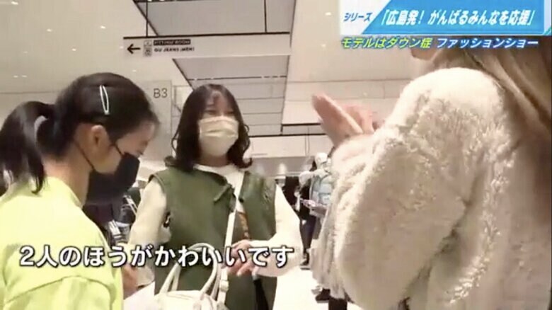 ダウン症の参加者（左）と一緒に服を選ぶ大学生サポーター