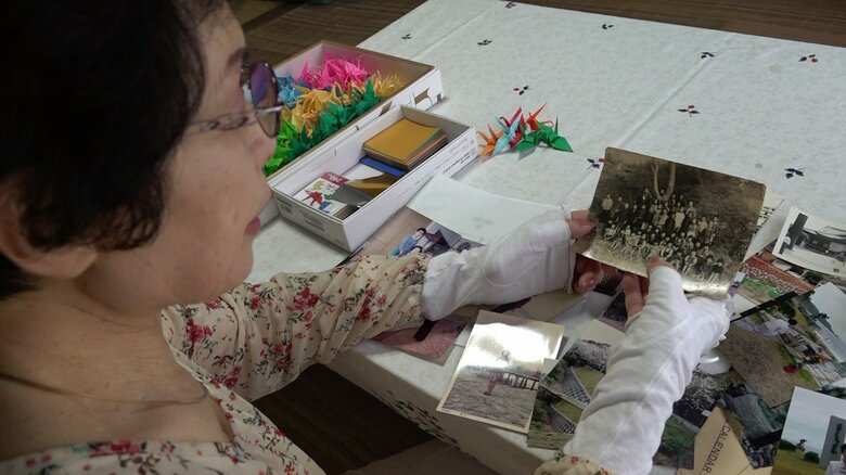 家族写真を見つめる田崎さん