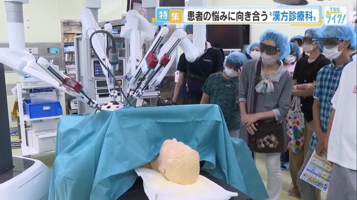 医師が操作するロボット手術を見学する参加者