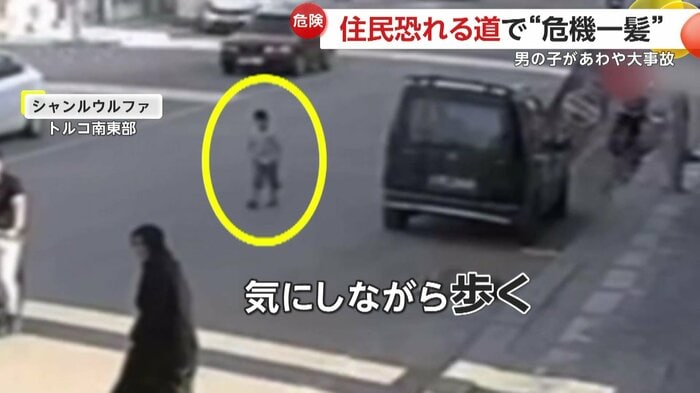 歩道の方を見ながら歩く男の子(IHA)