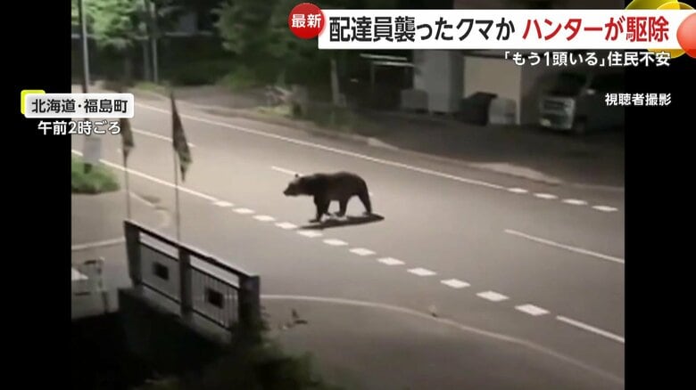 視聴者が自宅の窓越しに撮影した、深夜に道路を横断するクマ（18日、北海道・福島町）　①