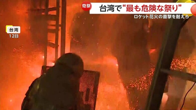 激しく飛び交う火花を浴びる祭りの参加者