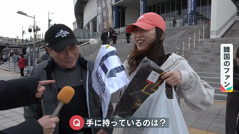 うれしそうに大谷選手のユニホームを見せてくれる韓国のファン