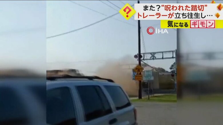 踏切周辺に砂煙が立ち込める