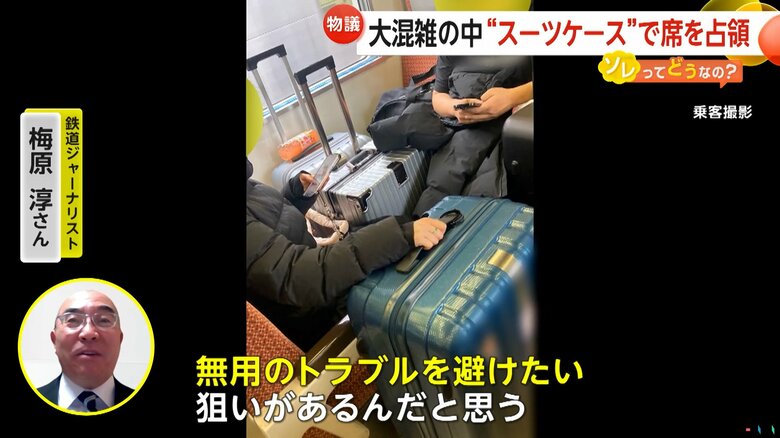 大型のスーツケースを中に置き、4人掛けのボックス席に座る2人の男性