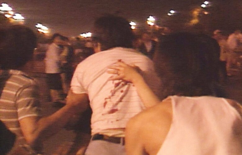 背中に銃弾を受け出血する市民