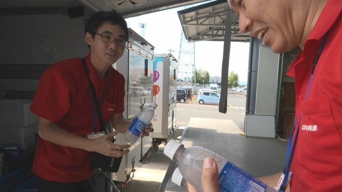 飲料を配る県民生協の従業員