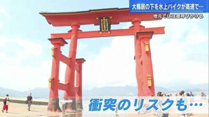 干潮時の大鳥居でレポートする五十川記者(左から3番目)
