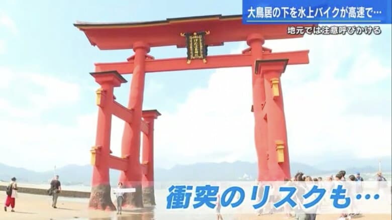干潮時の大鳥居でレポートする五十川記者（左から3番目）