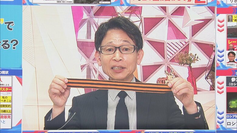 ロシアの街中で渡されたという「ゲオルギーリボン」を手にする中村教授