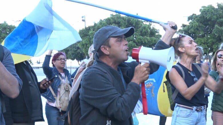 カナリア諸島自治州の旗を掲げて抗議の声を上げる島民