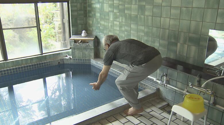 急いで男性を湯船から引き揚げる　※再現