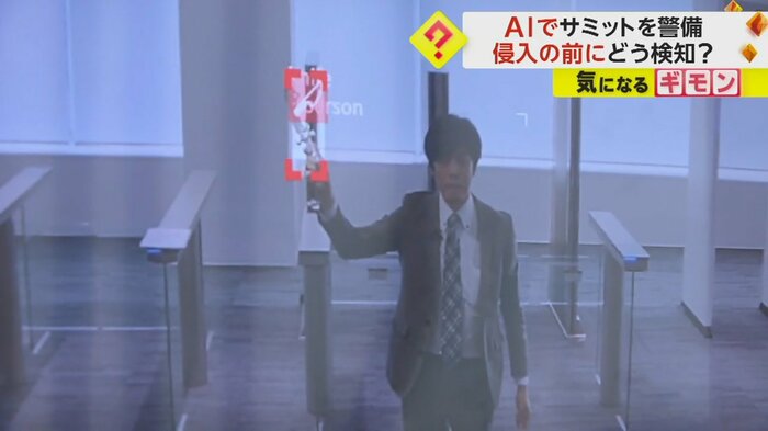 防犯カメラの映像。記者がおもちゃのナイフを手に取ると赤いマークが付いた
