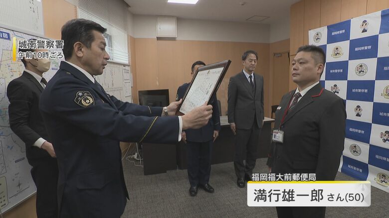 警察から感謝状を受け取る、郵便局勤務の満行雄一郎さん（50）