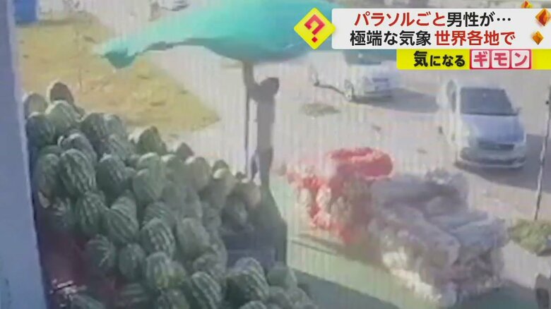 パラソルの傘を閉じるためによじ登る男性（andal Manav&Balikcilik）