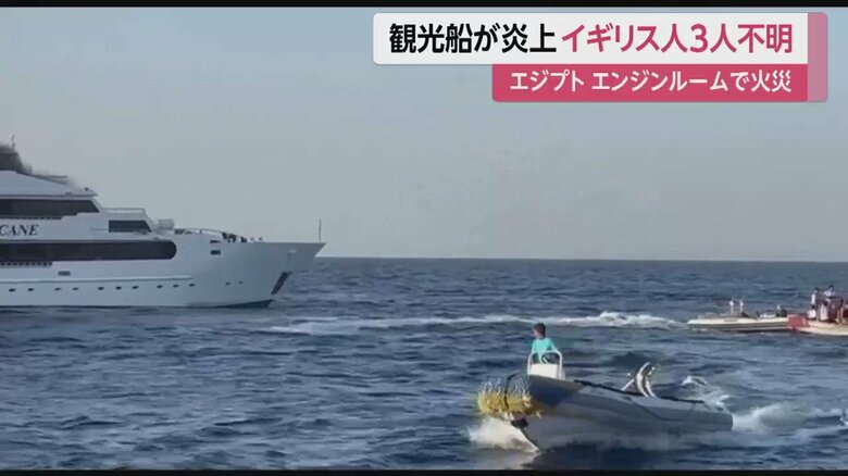 炎上する船を見つめる、救出された人々
