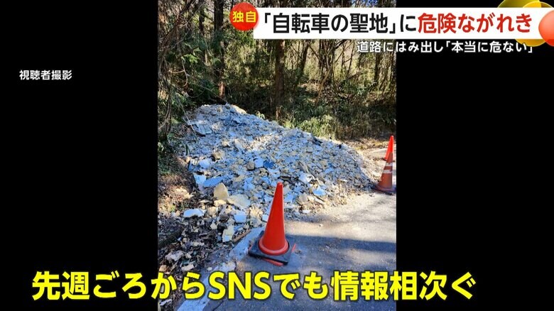 カーブした道路脇に積まれたがれきの山