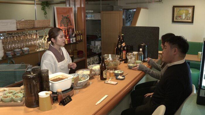 料理がずらりと並ぶカウンターで客との会話が弾む