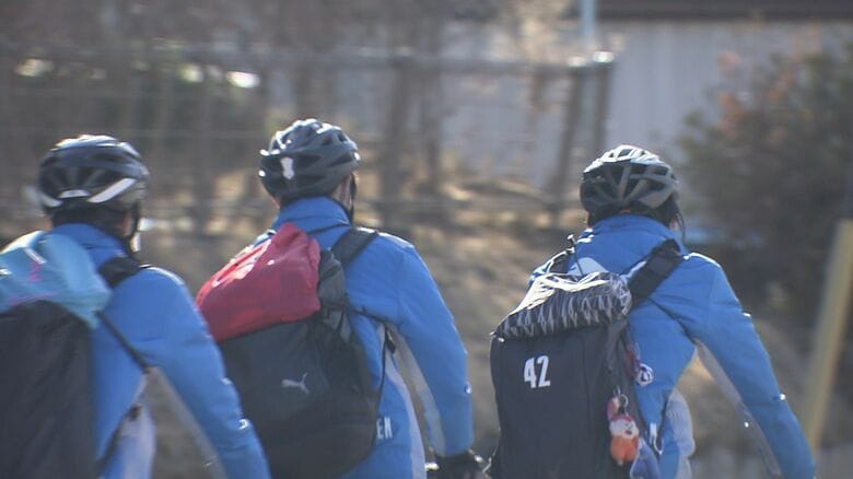 ヘルメットを着用して自転車通学する高校生