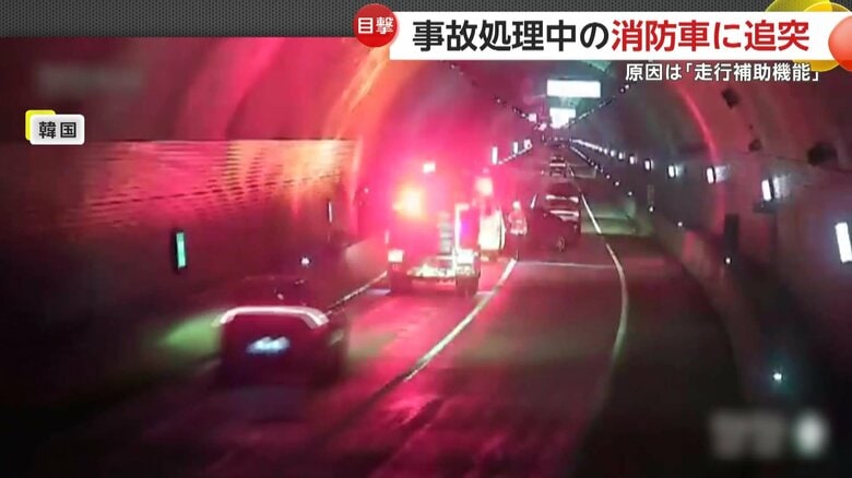 事故処理中の消防車に接近する車