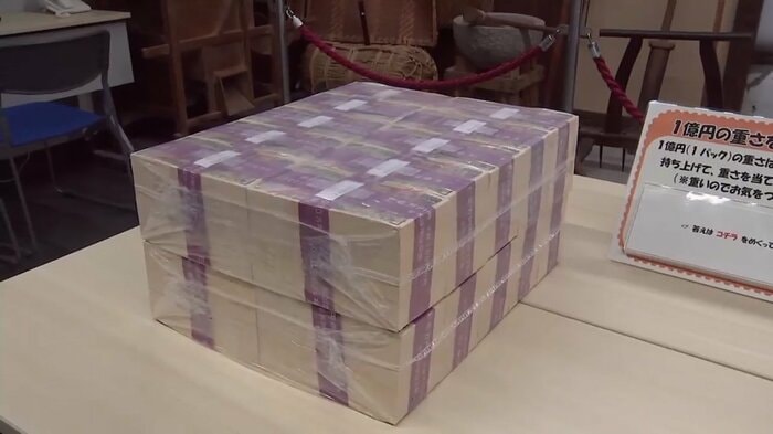 机の上に積み上げられた1億円の模造紙幣