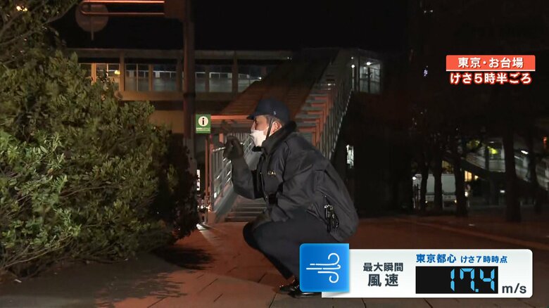 通行人が飛ばされためがねを探す警察官