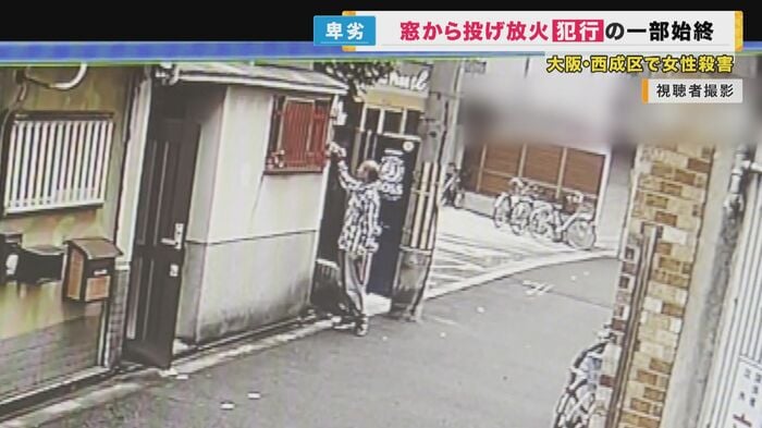 部屋の中に何かを投げ入れる新居田容疑者