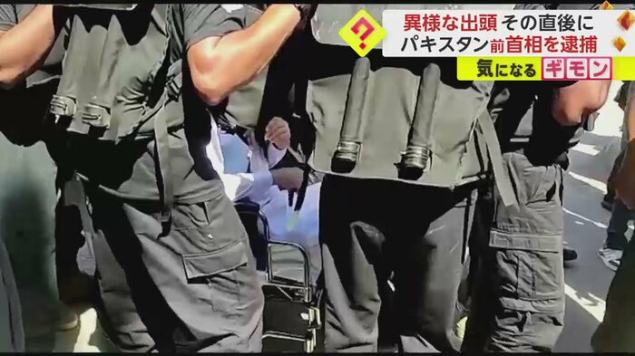 顔を隠しながら車椅子に座る、イムラン・カーン前首相