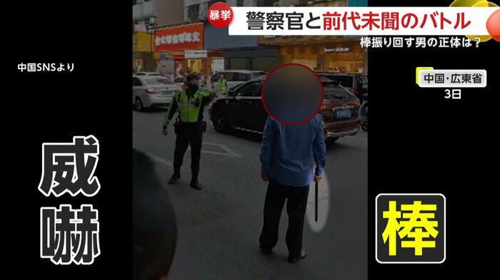 棒を持ち警察官に立ち塞がる男(中国SNSより)