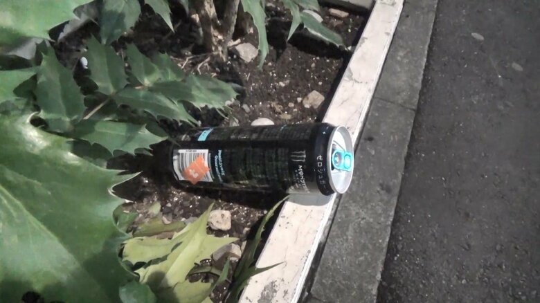 男性が座っていた場所に捨てられた空き缶