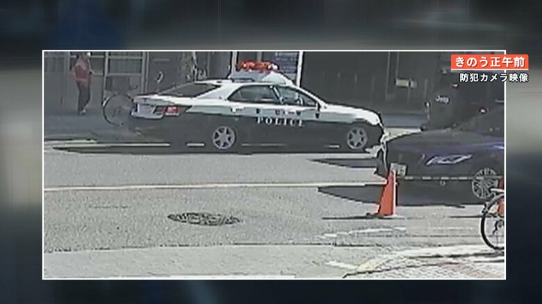 事件当日の正午前　警察車両から捜査関係者とみられる人々が