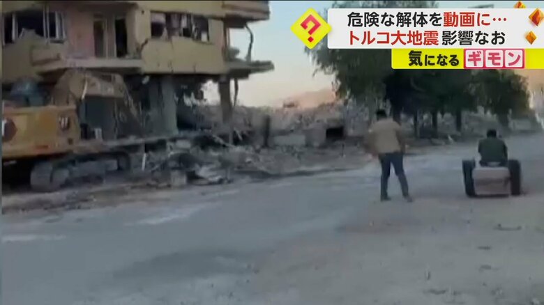 道路で人々が解体作業の見物をしている（IHA）