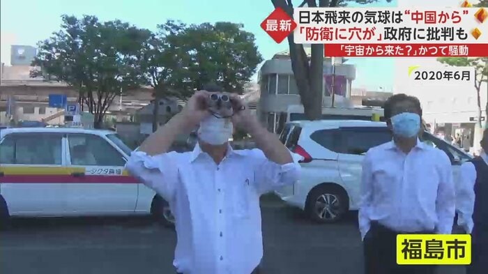 双眼鏡で“謎の球体”を見上げるタクシーの運転手