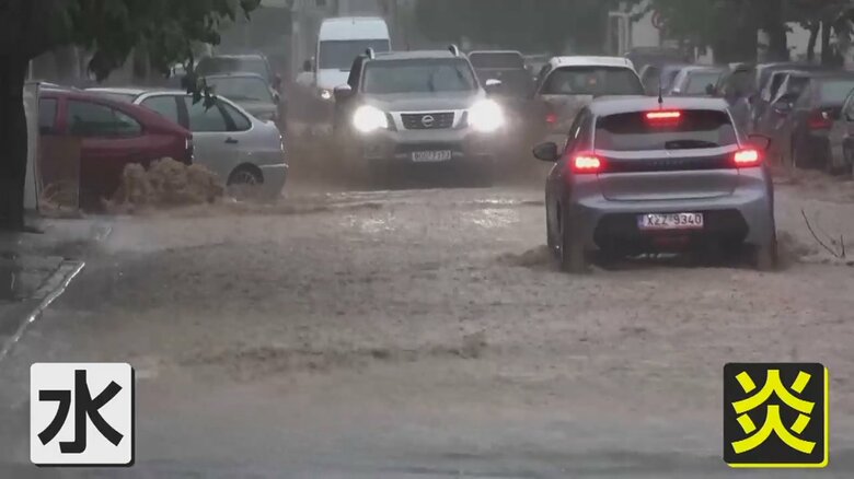 水浸しになった道路を車が進んでいる