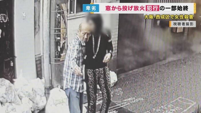 困惑する人の肩を叩く新居田容疑者