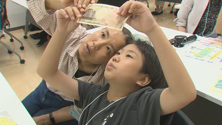 小学生“お札の秘密”に迫る！高度な偽札防止技術に驚きの声「知らない人に自慢したい」 “1億円の重さ”には「紙だからもっと軽いと思った」新潟｜FNNプライムオンライン