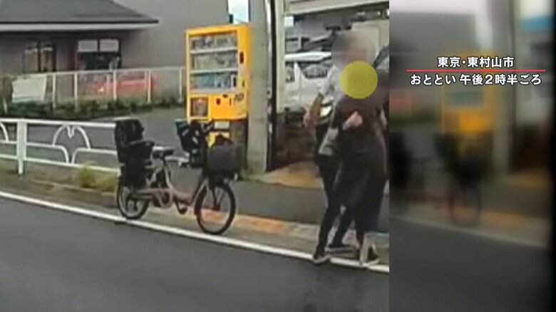 女性を抱きかかえて歩道に避難