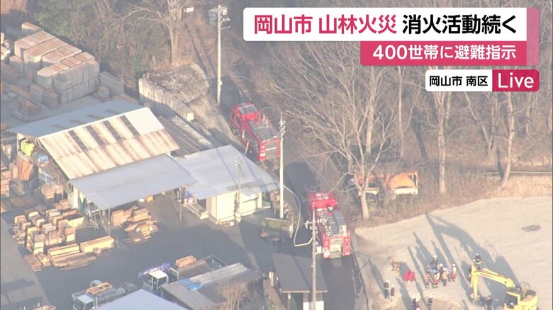 岡山市の山林火災で対応に追われる消防ら（23日）