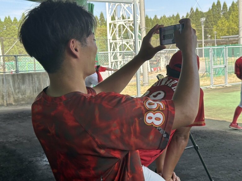 ブルペンにて投手を撮影する磯和氏