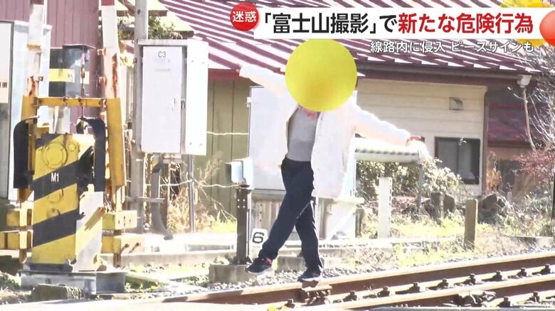 細い線路上に立ち、ポーズを決め撮影した女性