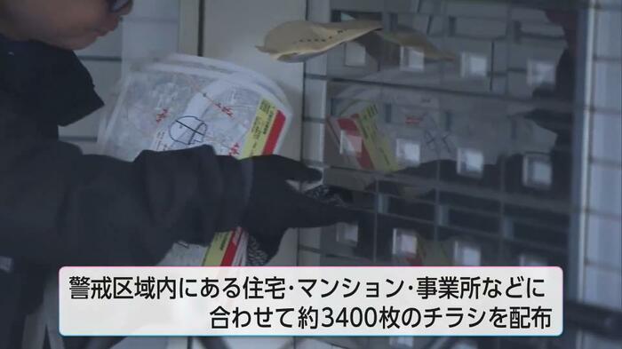 住宅を訪問しチラシを配布する担当者