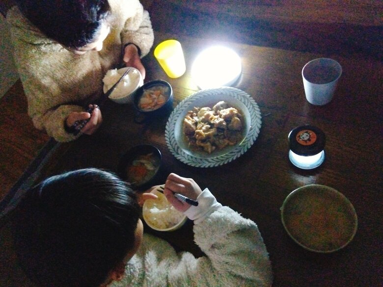 わがやの「避難訓練」。ランプの明かりだけで前の日の残り物やインスタントのお味噌汁を食べています。