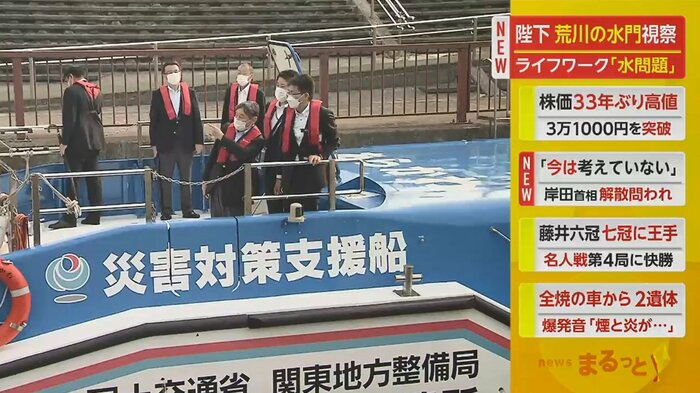 赤いライフジャケットを着用し、船のデッキに立たれる陛下