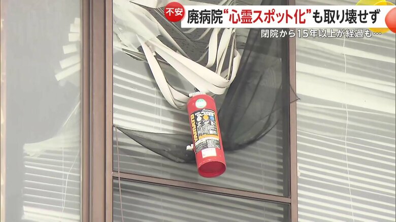 窓のブラインドにはなぜか消火器がぶら下がっていた