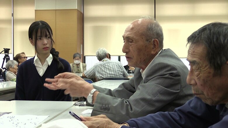 体験談を真剣に聞く関口さん（左）