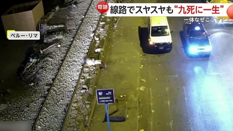 線路の上で寝る男性のすぐ上を列車が通過する瞬間（8日、ペルーの首都リマ）（1）