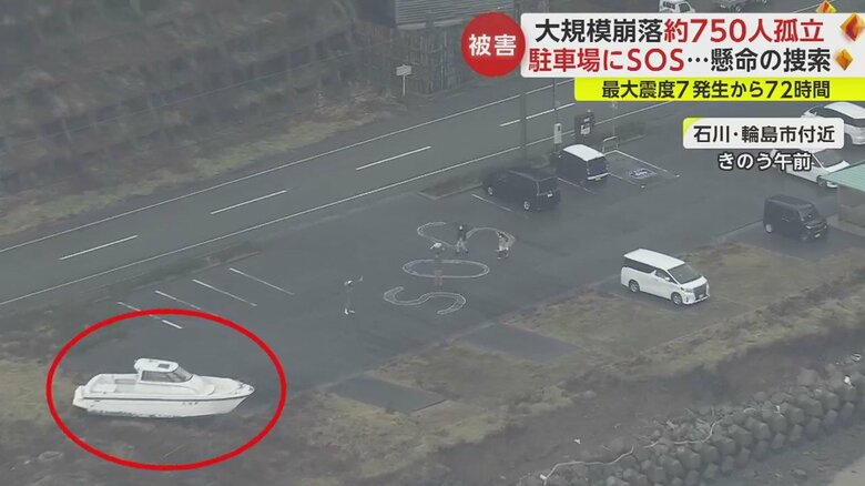SOSと書かれた駐車場には流されてきたと思われる船も見えた（赤丸部分）