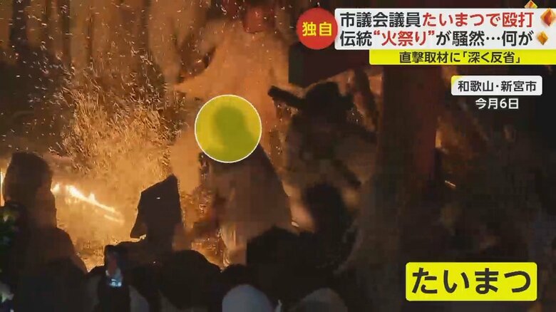 燃え盛るたいまつを何度もたたきつける男性