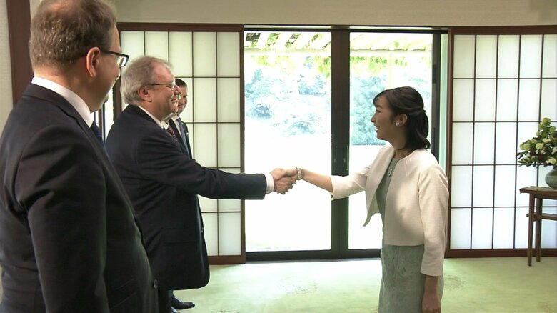 再会されたハンガリーの国会議員と固く握手をされる佳子さま